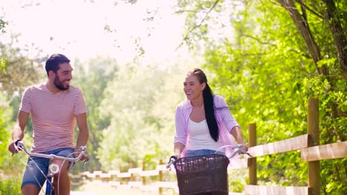 Happy Couple Riding Bicycles at Summer Park