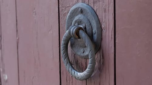 Vintage Bronze Door Knocker on the Wooden Door in Form of Hand