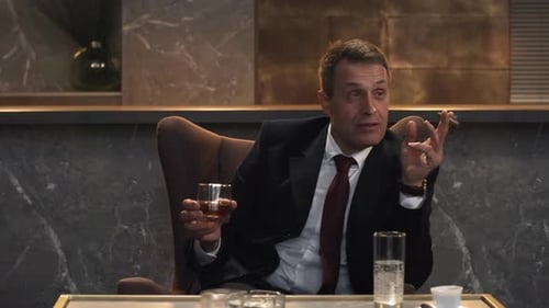 Man Smoking Cigar Holding Glass Indoors