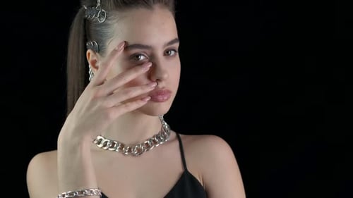 Stylish Woman with Bold Jewelry on Black Background
