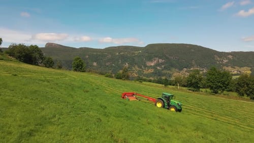 Machines de récolteuse de fourrage travaillant et fabriquant un andain pour l'ensilage dans les champs ruraux à Hjelmeland en aucun