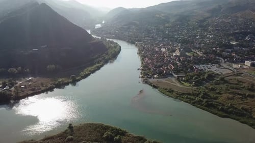 The confluence of two rivers. A small town stands on the banks of the river, around the mountain. Dr
