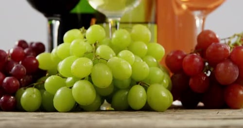 Various grapes and wines on wooden plank