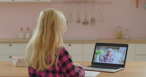 School Child Studying Online with Senior Female Teacher on Laptop Screen, Little Girl Has Online