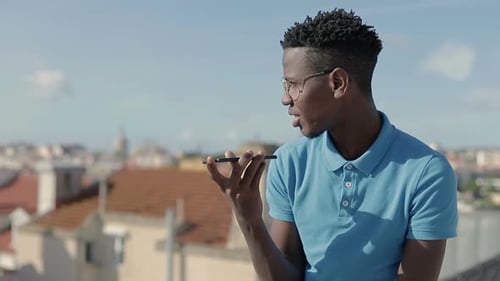 Junger afroamerikanischer Mann unterhält sich im lauten Regime auf dem Smartphone