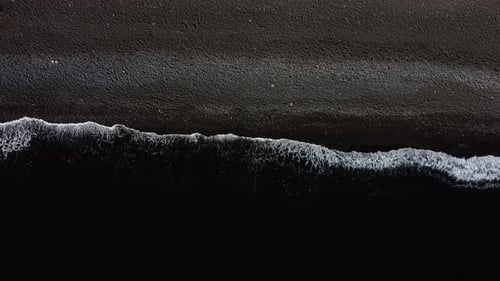 Top Down View on Waves on Black Sand Beach