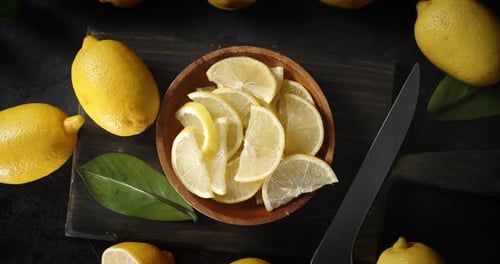 Yellow Lemons and Lemon Slices on Wooden Board
