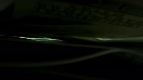 Stacks of Hundred Dollar Bills in the Dark