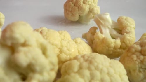Cauliflower Florets Falling into Bowl Macro Shot