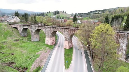 Cyclist riding on bicycle through old viaduct railway bridge