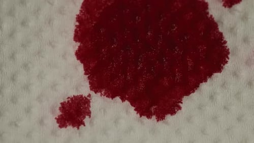 Blood-Red Stain on White Textured Surface