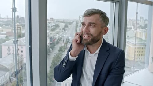 Smiling Businessman Talking on Phone in Office