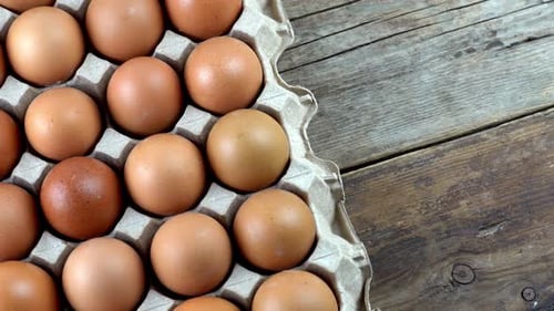 Brown Chicken Eggs in Carton on Rustic Wood Table