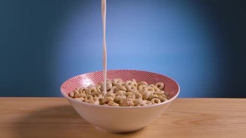 Pouring Milk over Cereal Loops in Bowl