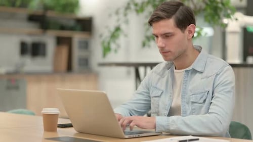 Creative Young Man Working on Laptop in Office
