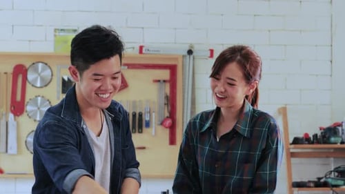 Carpenter workers man and woman designing construction for built-in furniture project in workshop