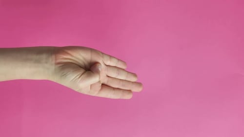 Hand Forms Fist Against Pink Background