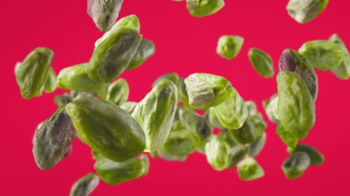 Shelled Pistachios Floating on a Red Backdrop