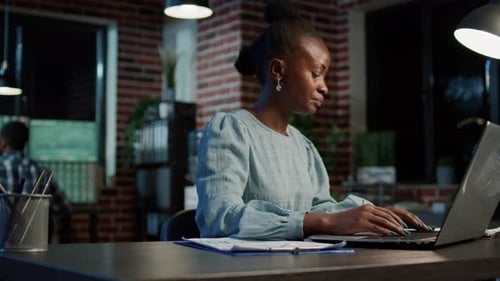 Hedge Fund Trader Using Charts Papers and Laptop to Check Stock Trade