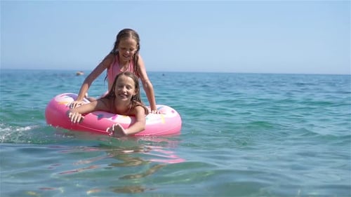 Kleine Mädchen, die in den Sommerferien Spaß am Tropical Beach haben und zusammen spielen