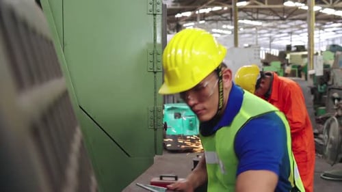 Intelligenter Fabrikarbeiter benutzt Maschine in der Fabrikwerkstatt
