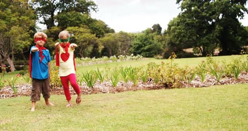 Children Dressed as Superheroes Play in Park