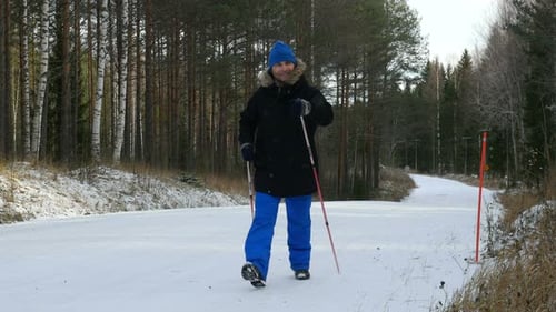 Young Man Does Sport, Fitness, Nordic Walking And Exercising Outdoors, Winter Forest, Countryside.