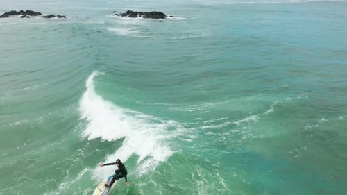 Surfer Rides Ocean Wave Aerial View