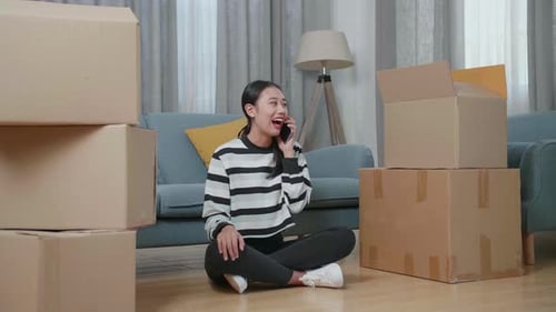 Woman Talking on Phone Amidst Moving Boxes