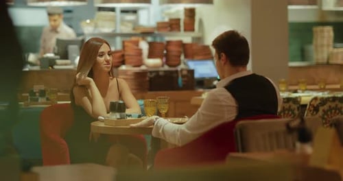 Beautiful Woman in Evening Dress is Having Dinner with an Elegant Man in a Cafe a Date