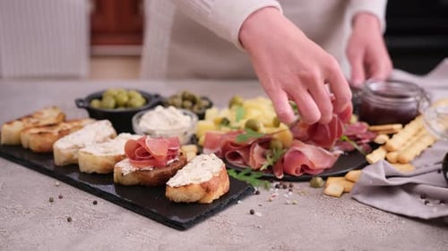 Preparing Charcuterie Board with Toasted Bread and Meats