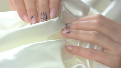 Woman Holding Fabric Showing Nail Art Design