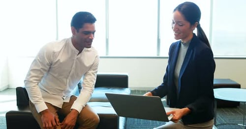 Adults Meet in Modern Corporate Office with Laptop