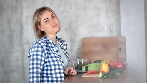 Young Woman Enjoys Fresh Vegetables in Kitchen