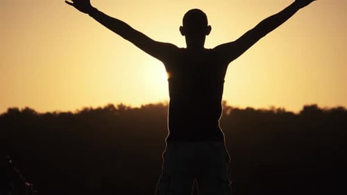 Man Silhouette Raising Arms at Golden Sunset