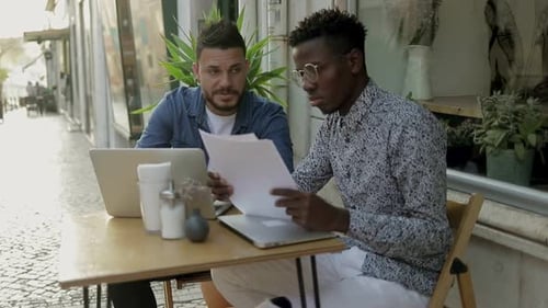 Des freelances spécialisés travaillant ensemble dans un café en plein air