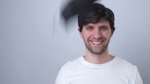 Close-up Portrait of a Man Removes a Black Medical Mask During the Quarantine of the COVID-19 Virus