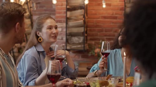Friends Toasting With Red Wine at Dinner