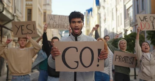 Young Adults Protest With Signs in an Urban Setting