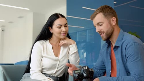 Photographer and Model Watch Photos Sitting in the Business Center