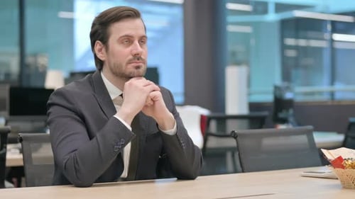 Homme d'affaires pensif assis au travail : remue-méninges