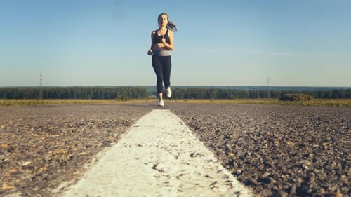 Young Woman Jogging on The Road