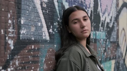 Teen Woman Smiling Leaning Against Graffiti Wall