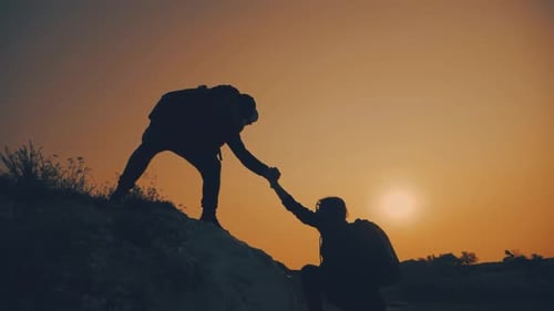 Helping Hand Reaching Mountain Top at Sunset