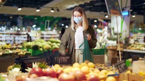 Woman Shopping for Citrus Fruit Wearing Surgical Mask