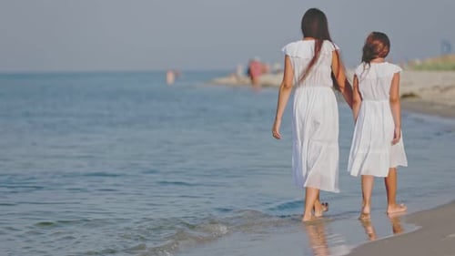 Mom and Daughter are Walking Near the Sea
