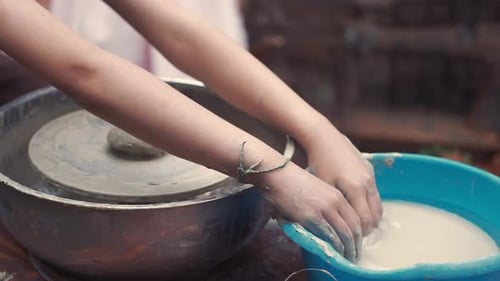 Des mains rapprochées fabriquent des pichets en poterie
