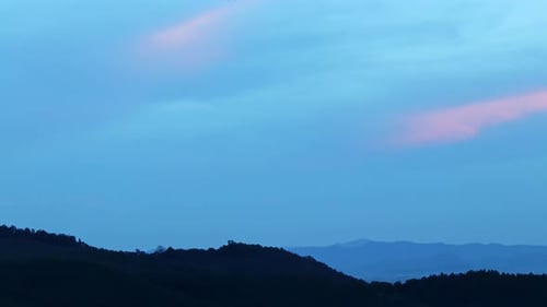 Magical Blue and Orange Clouds Swirl Over the Mountain at Sunset
