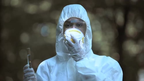 Biologist Putting on Protective Mask Showing Tube Infected Liquid, Radiation