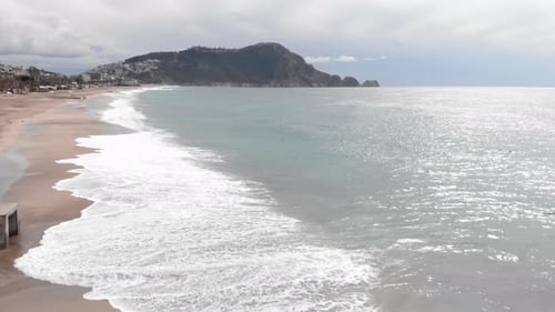 Empty beach with beautiful sea waves splashing and crashing on sand